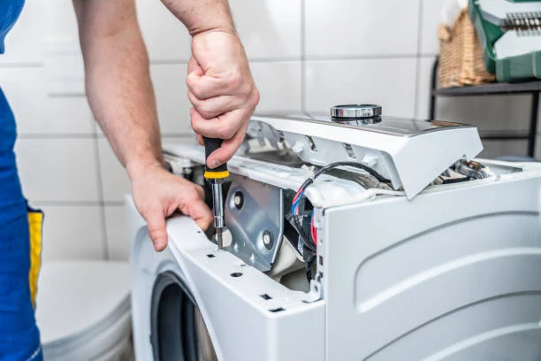 Close-up of a technician repairing the exposed mechanism of a washing machine